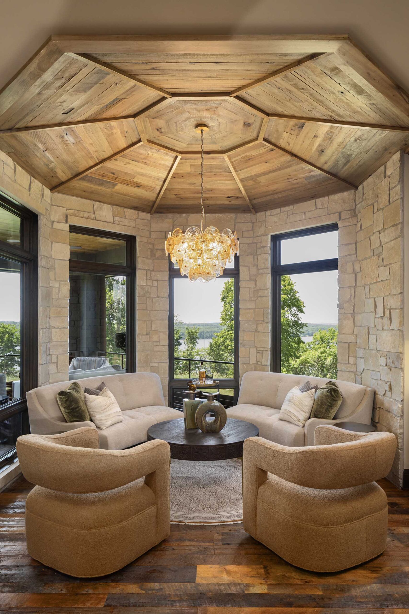 A modern living room with a wooden ceiling and couches in a Tuscan Mediterranean home.