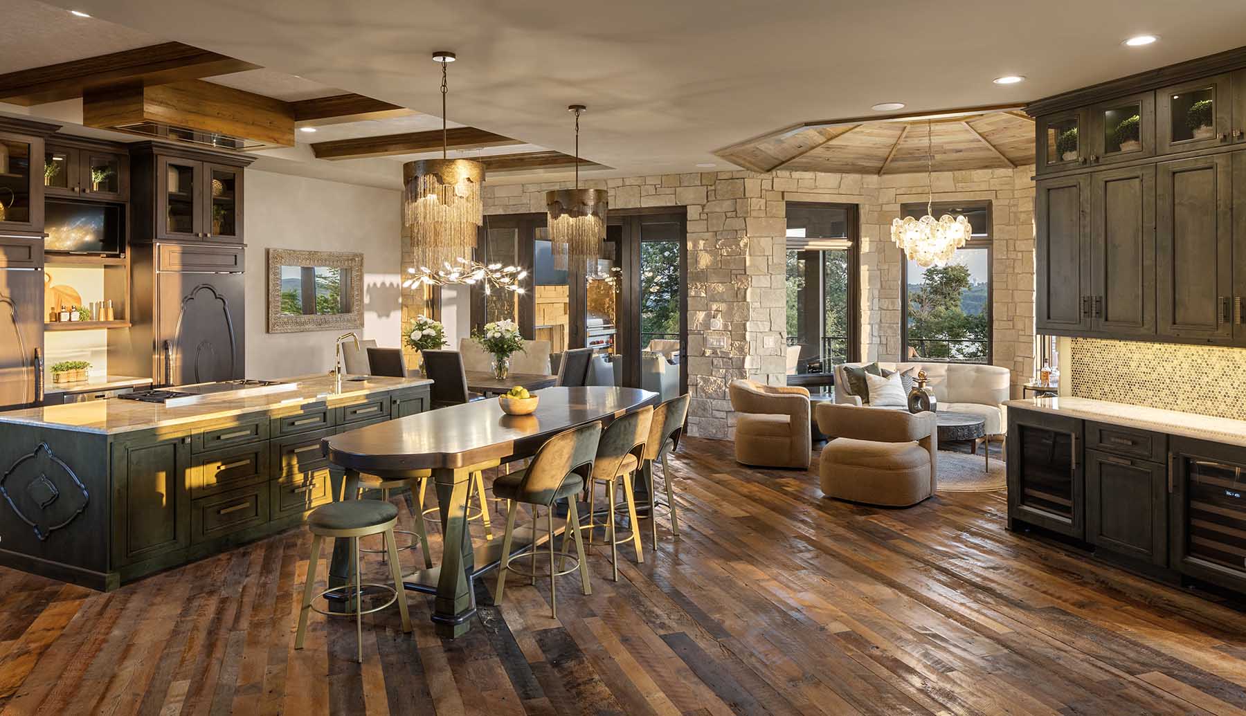 A large kitchen with wood floors and a bar area in a Modern Tuscan Mediterranean home.