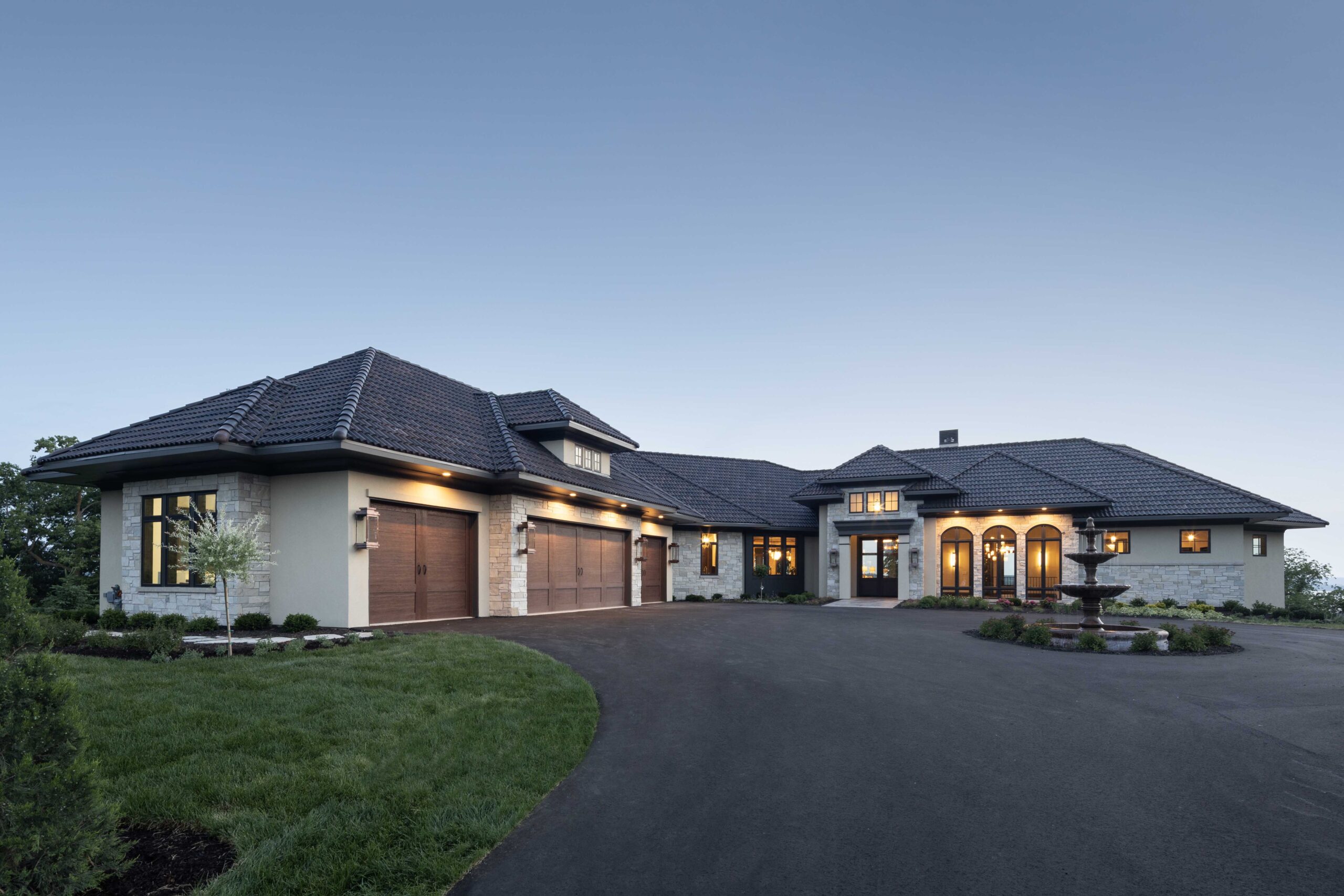 A stunning Modern Tuscan Mediterranean home featuring a spacious driveway and attached garage.
