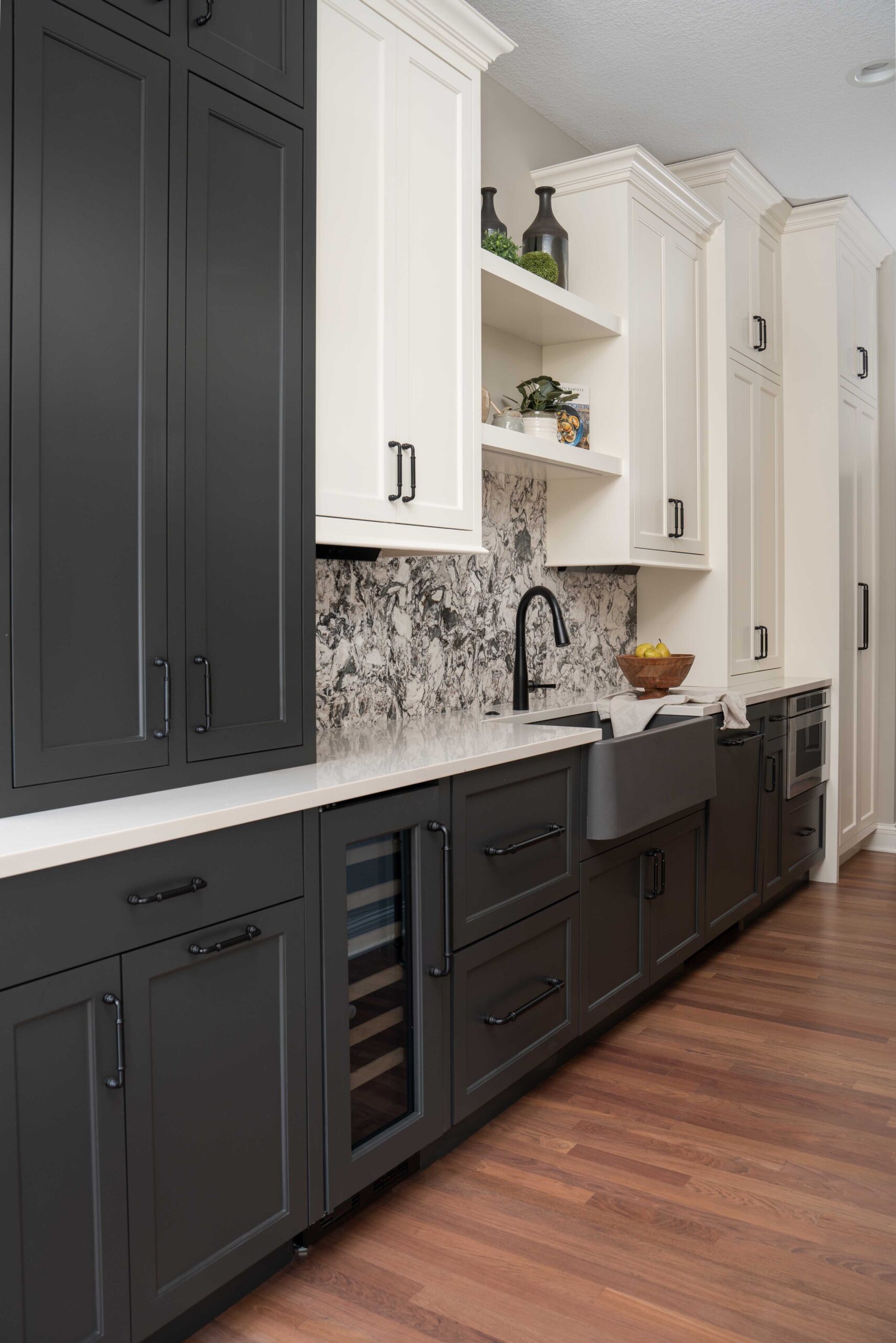 A modern kitchen with black cabinets and white counter tops.