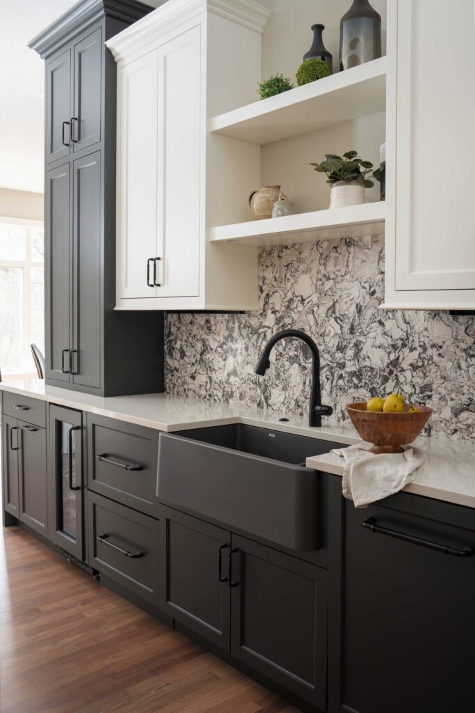 A modern kitchen with black and white cabinets and a black sink.