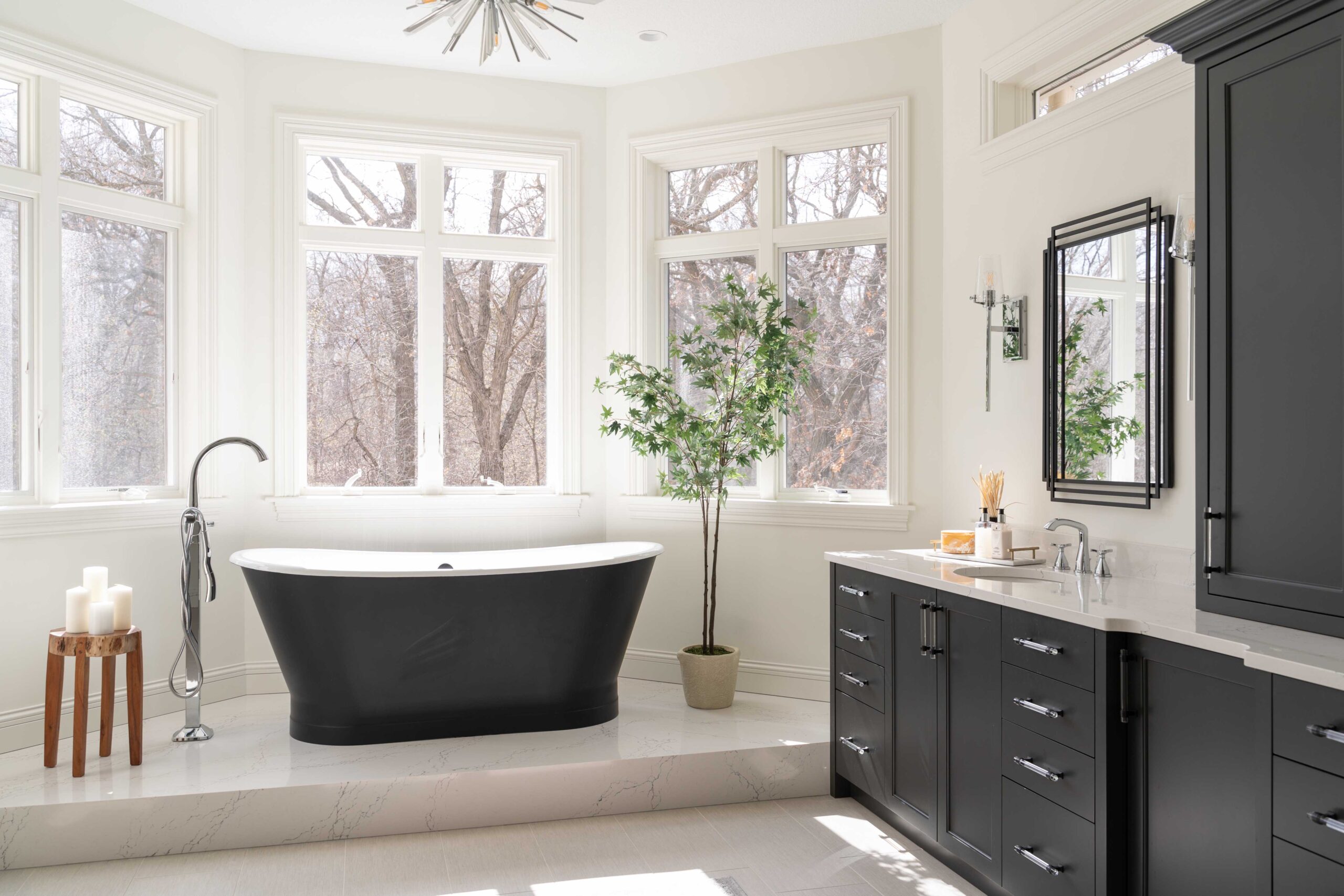 A modern bathroom remodel with sleek black cabinets and a striking black tub.