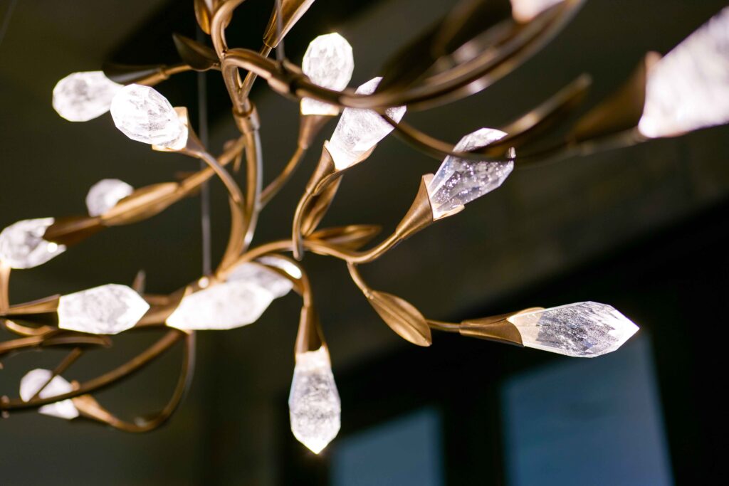 A modern chandelier adorned with gold leaves and crystals, perfect for a Tuscan or Mediterranean-inspired home.