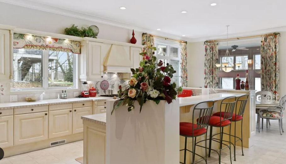 A woodside kitchen remodel with white cabinets and red stools.