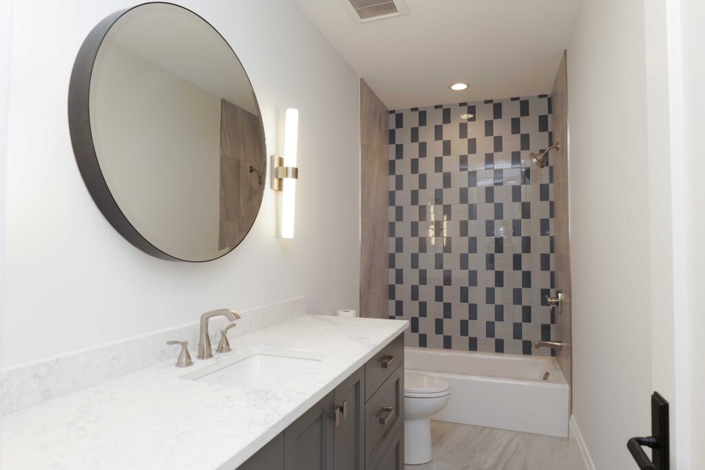 A bathroom with tiled walls and a mirror.