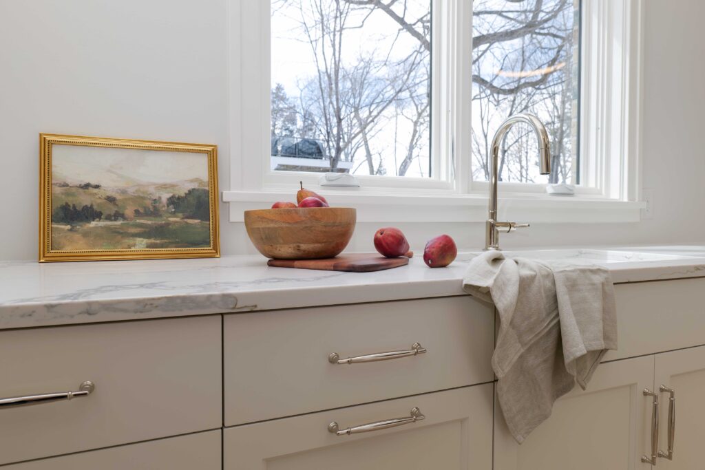 A white kitchen with a sink and a window.