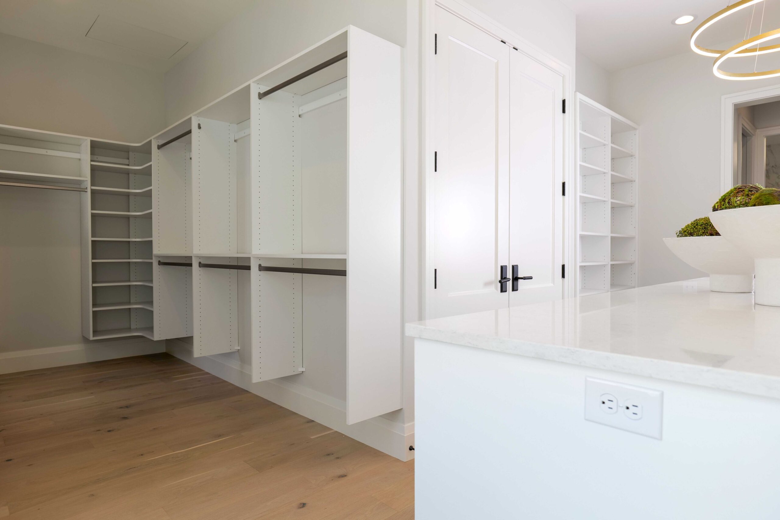 A white walk in closet with shelves and drawers.