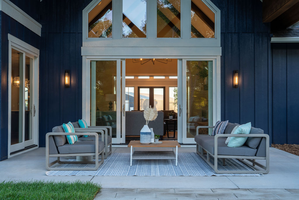 A transitional patio with a blue and gray color palette featuring a table and chairs.
