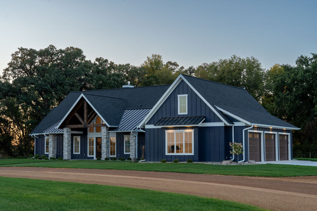 A transitional farmhouse with a blue exterior and a garage.