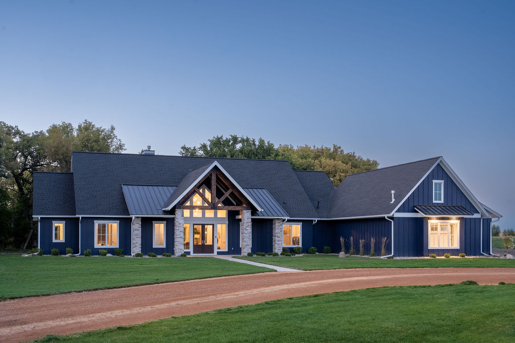 A Transitional Farmhouse home with a blue exterior and a gravel driveway.