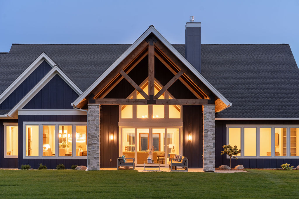 The exterior of a Transitional Farmhouse home at dusk.
