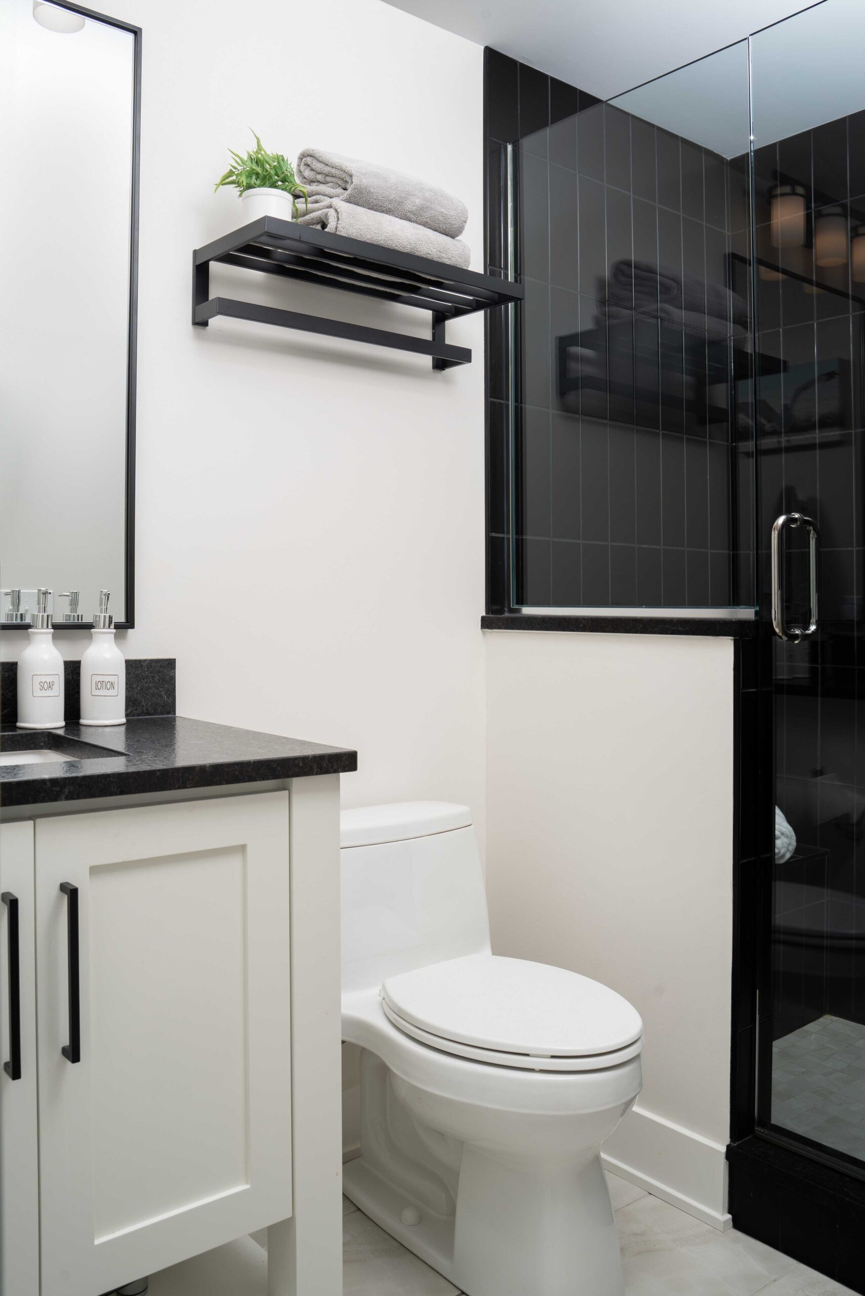 An Orchard Lake Remodel featuring a black and white bathroom with a toilet and shower.