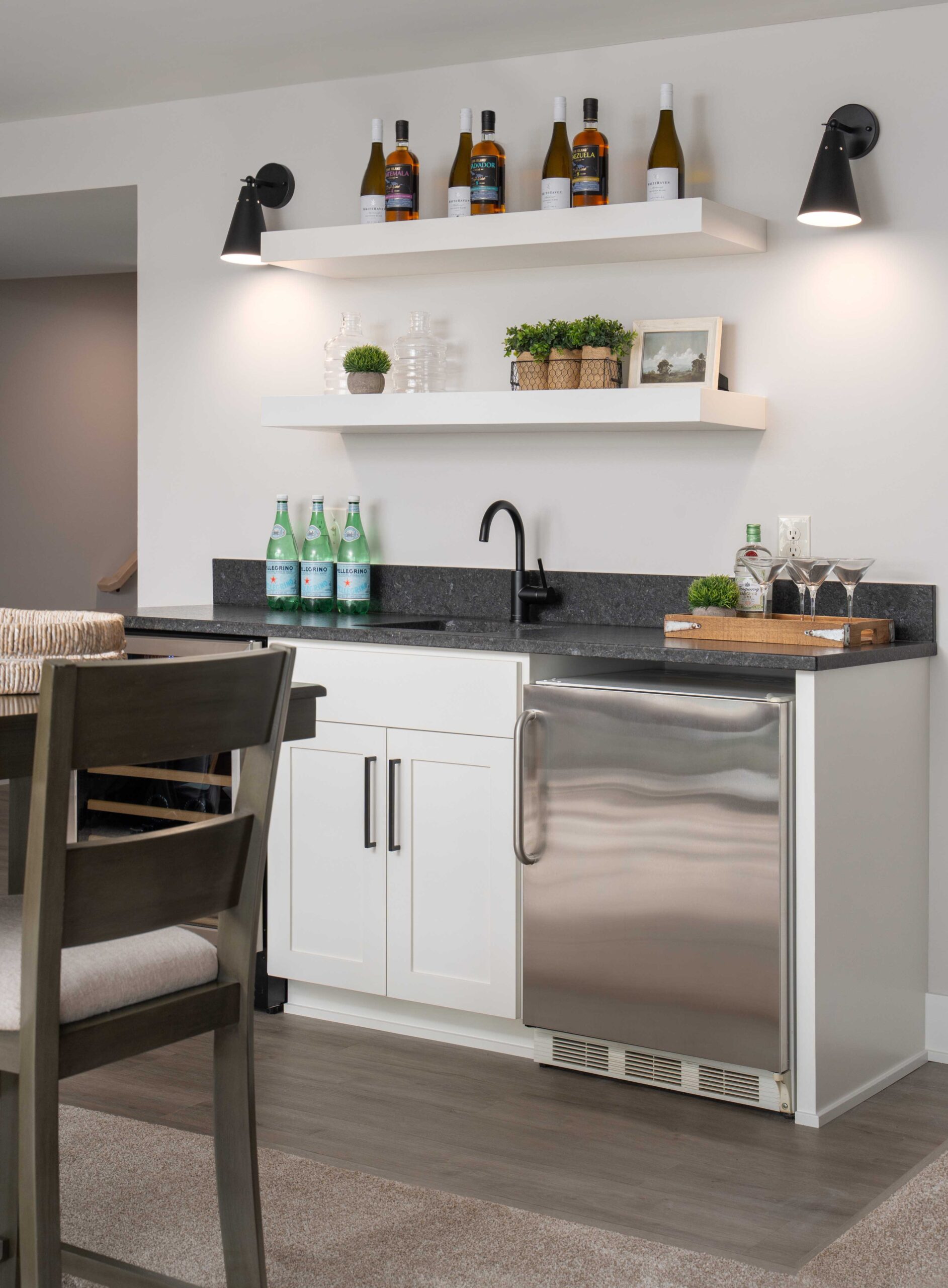 The Orchard Lake Remodel features a kitchen with a refrigerator, sink, and bar stools.