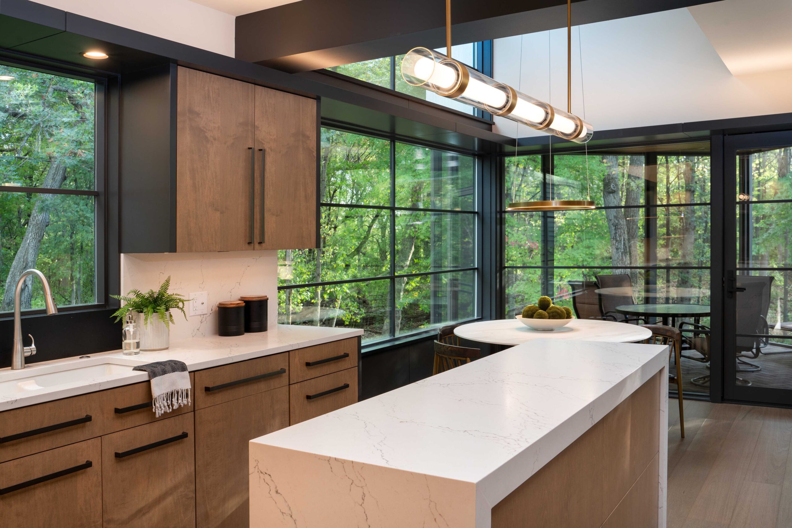 A modern kitchen with a large window overlooking a wooded area in Bloomington.