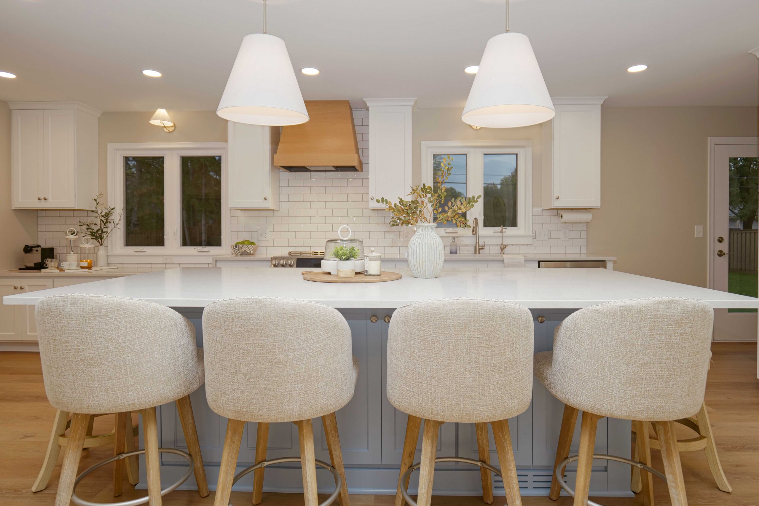 A coastal style kitchen remodel with a center island and bar stools.