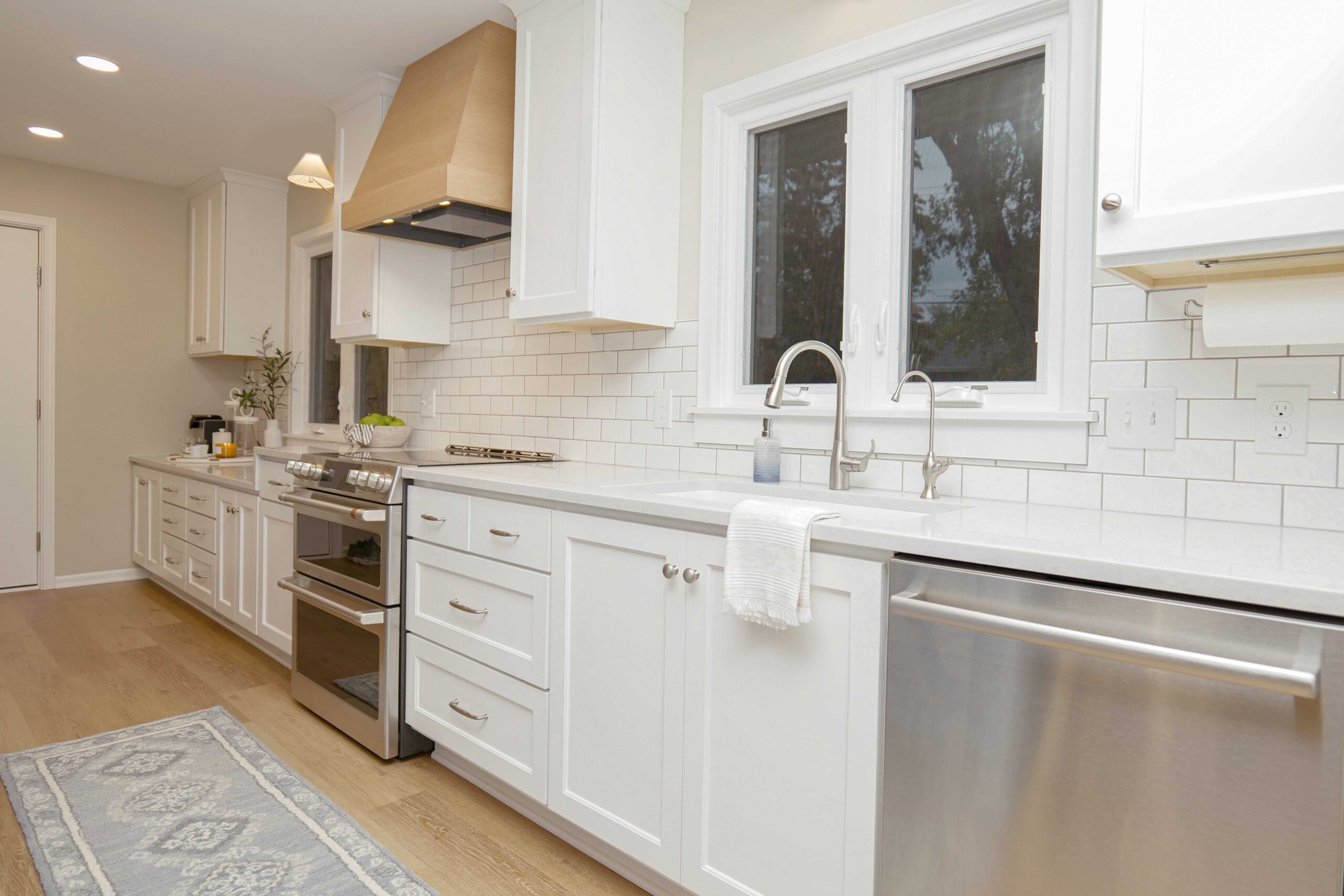 A coastal style kitchen remodel with white cabinets and a wooden floor.