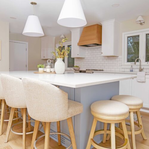 A coastal style kitchen remodel with a center island and stools.