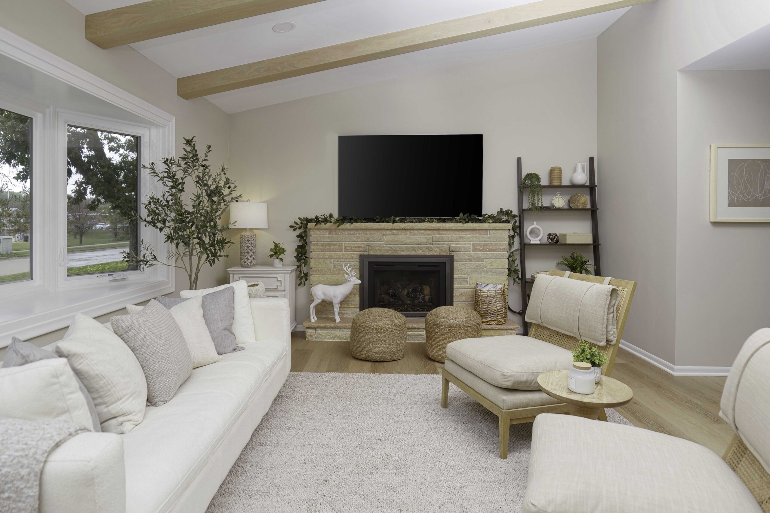 A coastal style living room with white furniture and a fireplace.