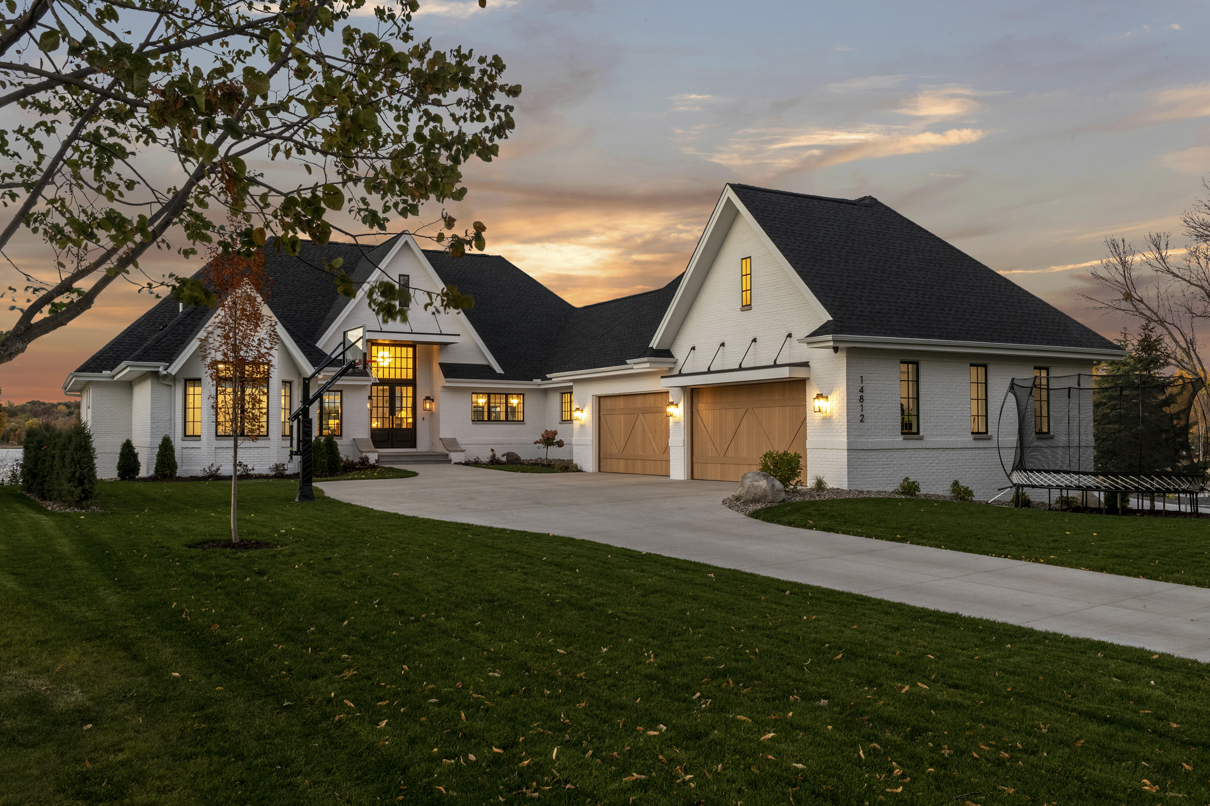 A modern home with a large driveway and large garage.