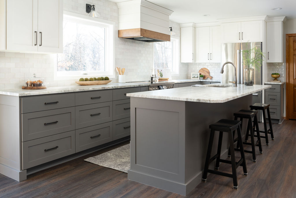 A modern cottage kitchen with white cabinets and gray countertops.